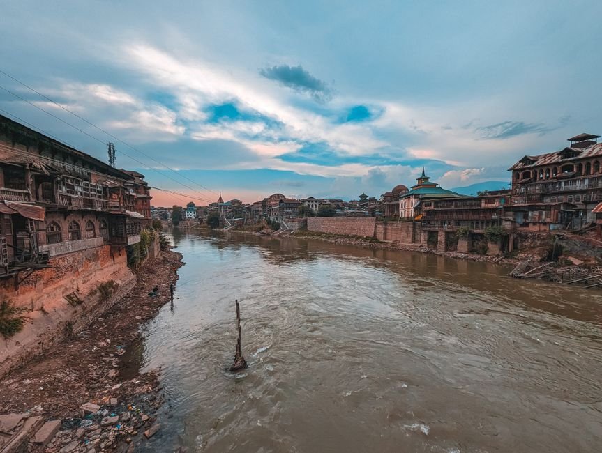 Jammu and Kashmir: Jhelum River Levels Rise Amidst Heavy Rainfall, Authorities on Alert Picturesque cityscape of Srinagar with a view of the Jhelum River at sunset, showcasing historic architecture.