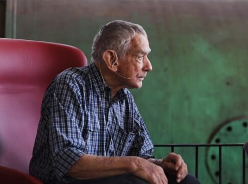 Profile of senior man with microphone speaking indoors. Profile of senior man with microphone speaking indoors.