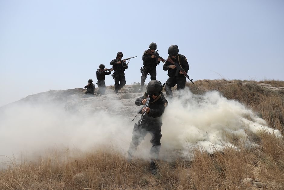 Houthi Threats to Red Sea Shipping Route Escalate, Risking Alternative Oil Transit Soldiers advancing through a field with smoke during a training exercise.