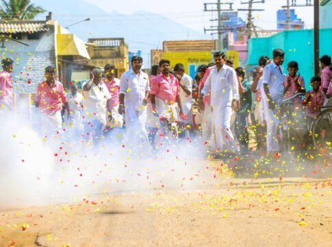 Vibrant street celebration with people amidst firecrackers and colorful confetti during the day. Vibrant street celebration with people amidst firecrackers and colorful confetti during the day.
