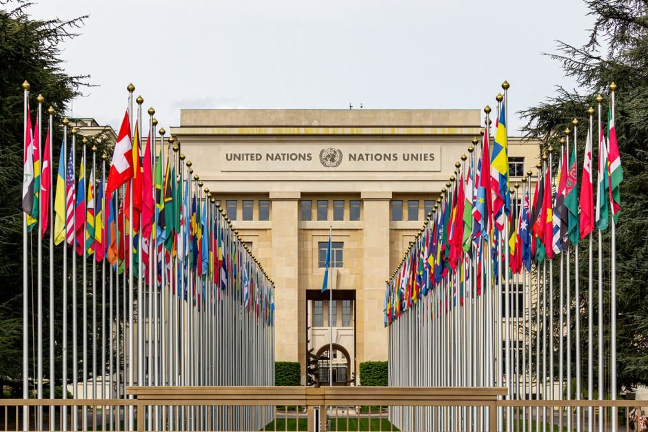 UN Leaders Urge Enhanced Global Cooperation for Disaster Risk Reduction View of the United Nations Office in Geneva adorned with flags of various countries.