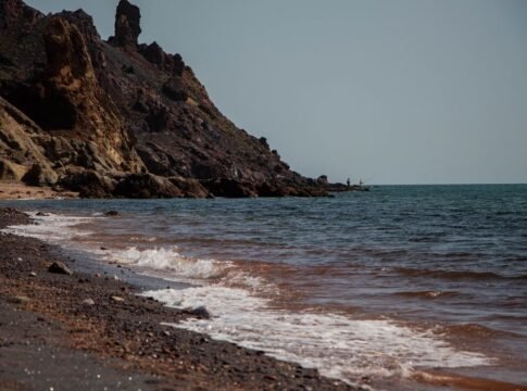 Waves crash on the rocky shore of Hormoz Island, Iran with clear blue skies. Waves crash on the rocky shore of Hormoz Island, Iran with clear blue skies.