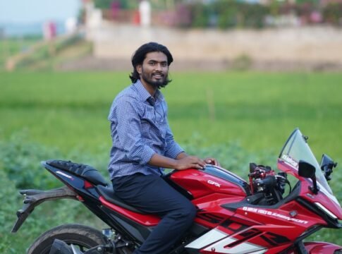 Young man on a stylish red motorcycle enjoying a ride through the scenic countryside. Young man on a stylish red motorcycle enjoying a ride through the scenic countryside.