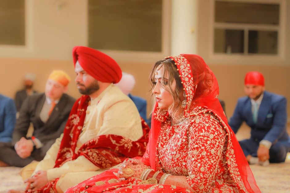 Ludhiana Sanitary Workers End Six-Day Strike After Talks with Minister A bride and groom in traditional attire during an Indian wedding ceremony inside a venue.