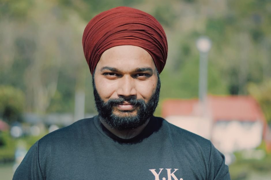 Punjab Congress Worker Who Raised Pro-Channi Slogans Faces NDPS, Abetment-to-Suicide Charges A cheerful man wearing a red turban and black t-shirt enjoys a sunny day outdoors.