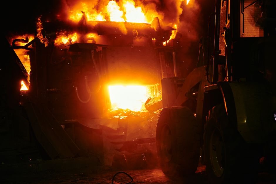 Three Labourers Dead, Two Injured in Karnataka Factory Chemical Leak A dramatic industrial fire with flames engulfing machinery in a nighttime scene.