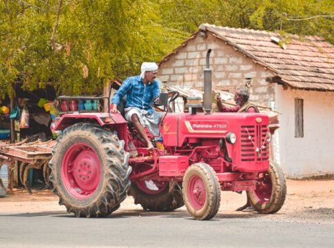 A farmer driving a red Mahindra tractor in Aranthangi, Tamil Nadu, India, showcasing rural life. A farmer driving a red Mahindra tractor in Aranthangi, Tamil Nadu, India, showcasing rural life.