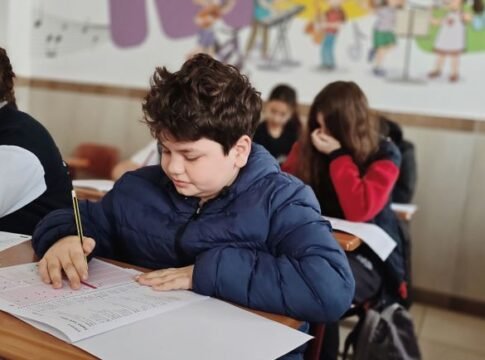 A group of children taking a test with focus and concentration in a classroom setting.