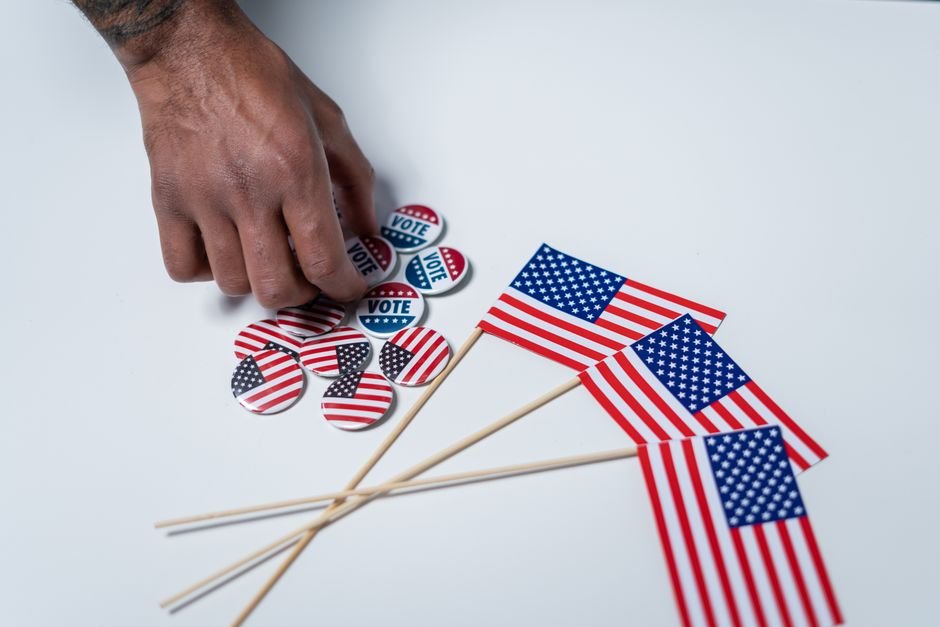 Democrats Finalize 2028 Primary Calendar, Elevating South Carolina A hand reaches for voting buttons and American flags on a white background.