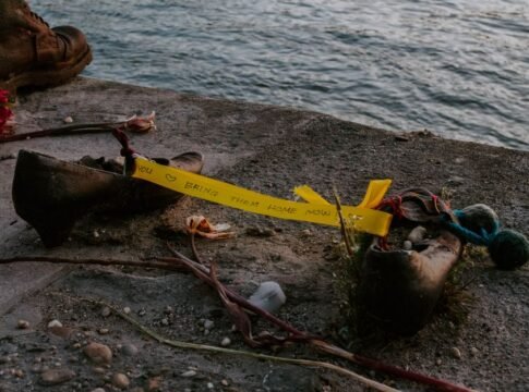 A moving memorial on the Danube riverbank in Budapest with shoes and a heartfelt message.