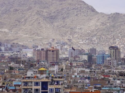 A panoramic view of Kabul city with high-rise buildings set against a mountainous backdrop.
