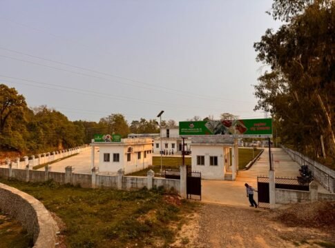 A rural facility with an open gate, surrounded by trees and a sunset sky, presents a peaceful rural setting.