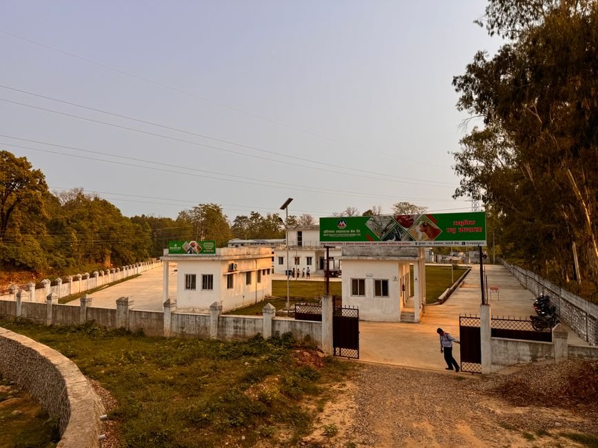 Bihar Pilgrim Dies of Cardiac Arrest During Budha Amarnath Yatra in Poonch A rural facility with an open gate, surrounded by trees and a sunset sky, presents a peaceful rural setting.