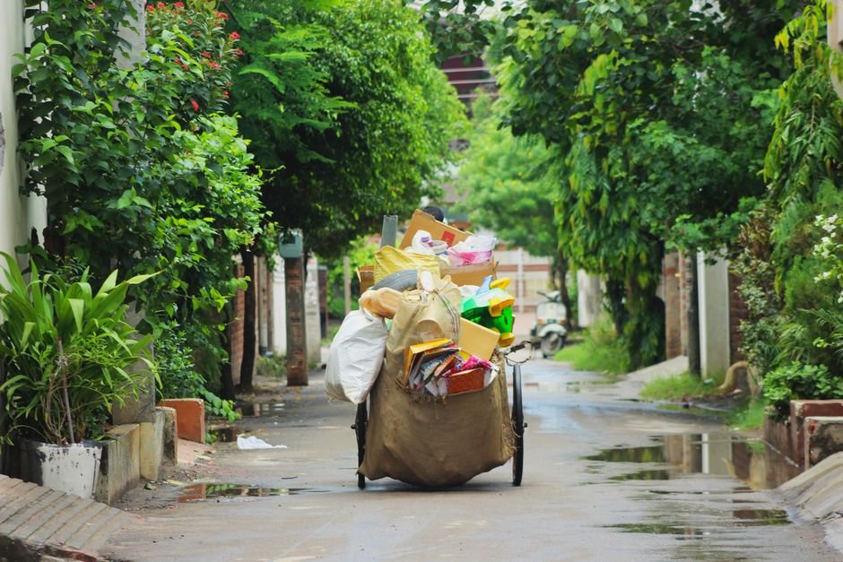 A street cart full of recyclable items on a lush, green street in Ludhiana, India.