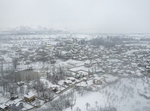 A stunning aerial view of a snow-covered town nestled in a winter landscape.