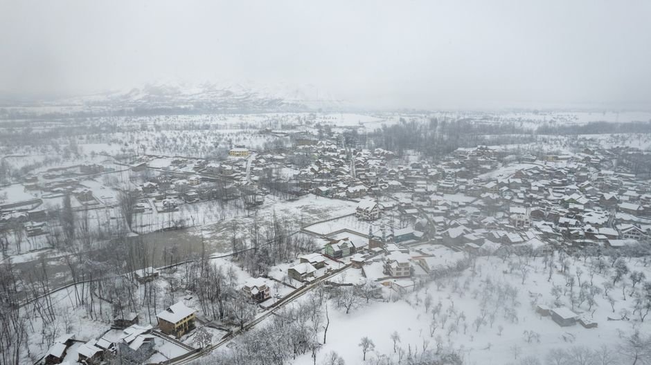 Jammu and Kashmir: Sopore Police Conducts Significant Officer Reshuffle A stunning aerial view of a snow-covered town nestled in a winter landscape.