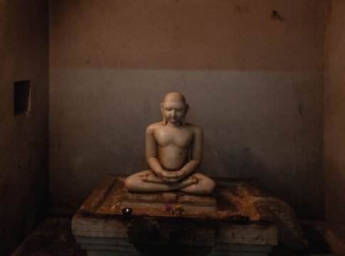 A tranquil marble statue in a dimly lit temple in Kanchipuram, India, exuding calmness.