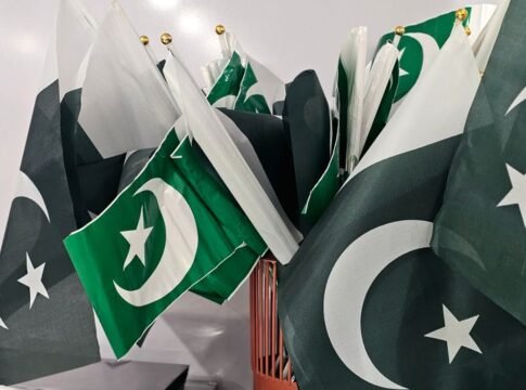 A variety of Pakistani flags grouped together indoors, emphasizing national pride.