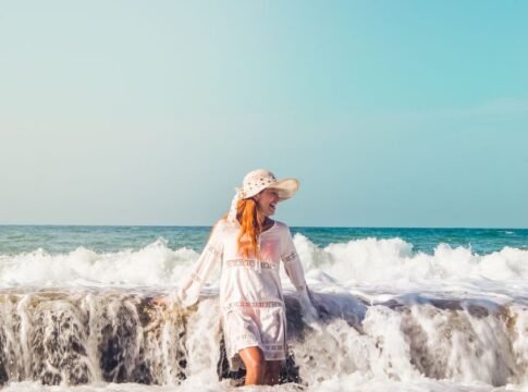 A woman in a sun hat enjoys the waves at La Sabana Beach, Venezuela. A woman in a sun hat enjoys the waves at La Sabana Beach, Venezuela.