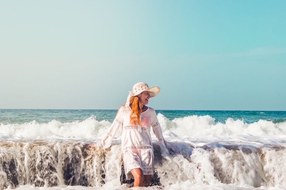 Devastation in La Guaira: Venezuela’s Coastal City Reimagined After Deadly Earthquakes A woman in a sun hat enjoys the waves at La Sabana Beach, Venezuela.