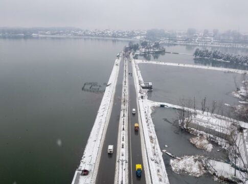 Aerial shot of a snow-covered bridge and road in Srinagar, Kashmir, during winter. Aerial shot of a snow-covered bridge and road in Srinagar, Kashmir, during winter.
