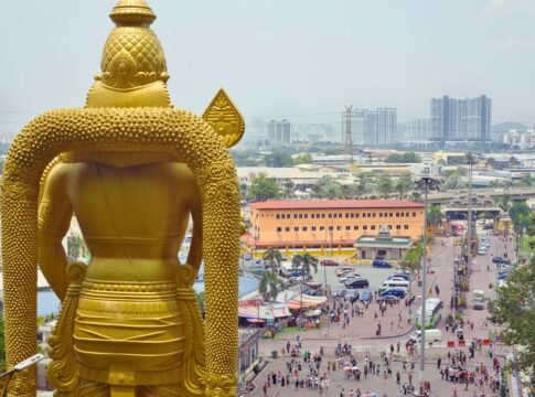 Aerial view of Batu Caves with the golden Murugan statue and Kuala Lumpur cityscape beyond. Aerial view of Batu Caves with the golden Murugan statue and Kuala Lumpur cityscape beyond.