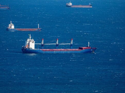 Aerial view of multiple cargo ships navigating through the vast blue ocean, capturing maritime commerce. Aerial view of multiple cargo ships navigating through the vast blue ocean, capturing maritime commerce.