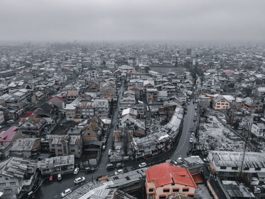 Jammu and Kashmir Engineer and Activist Mohammad Anwar Ashai Passes Away in Srinagar Aerial view of snowy Srinagar cityscape, showcasing rooftops and winding roads in winter.