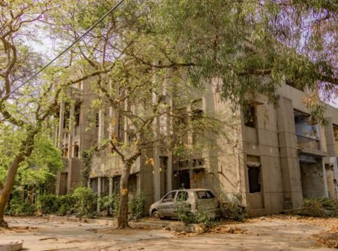 An abandoned building surrounded by lush greenery and an old car, captured in Delhi, India. An abandoned building surrounded by lush greenery and an old car, captured in Delhi, India.