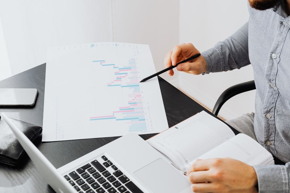 Jammu and Kashmir Records Over 3,700 New Beneficiaries Under PM-VBRY, Lok Sabha Informed An office setup with a person analyzing a graph printout while using a laptop and notebook.