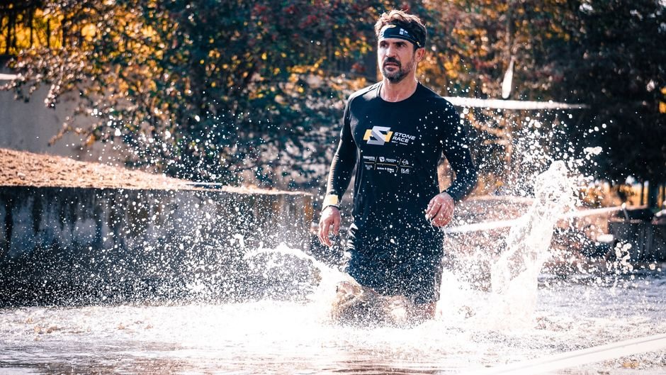 US Envoy to India Sergio Gor to Undertake First Visit to Kashmir Valley Athlete running through water splash during outdoor obstacle race.