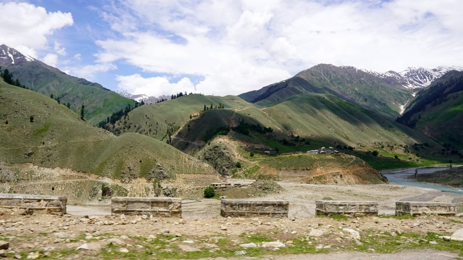 South African Tourist Dies in Himachal’s Parbati Valley Breathtaking view of Naran Valley's lush hills and river in summer.