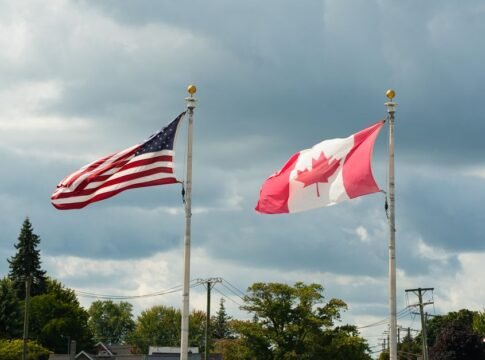 Canadian and American flags waving under a cloudy sky in Harbor Beach, MI. Canadian and American flags waving under a cloudy sky in Harbor Beach, MI.