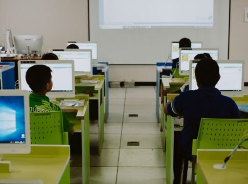 Children focus on computers in a modern classroom setting. Children focus on computers in a modern classroom setting.