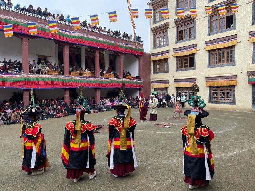 Colorful masked dance performance at the Hemis Festival in a courtyard in India.