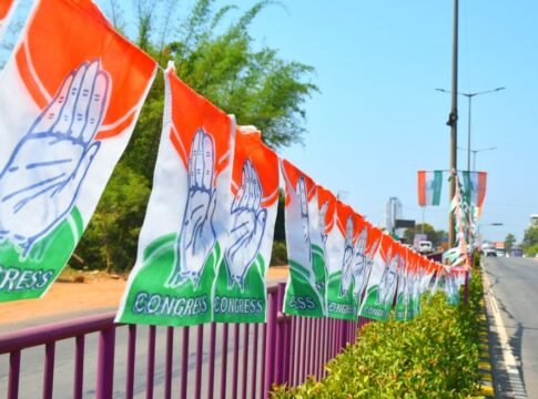 Congress party flags hanging on a roadside railing in Mangaluru, India, symbolizing political promotion.