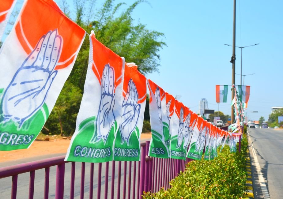 Punjab Congress Event Marred by Pro-Channi Slogans in Barnala Amid Unity Calls Congress party flags hanging on a roadside railing in Mangaluru, India, symbolizing political promotion.