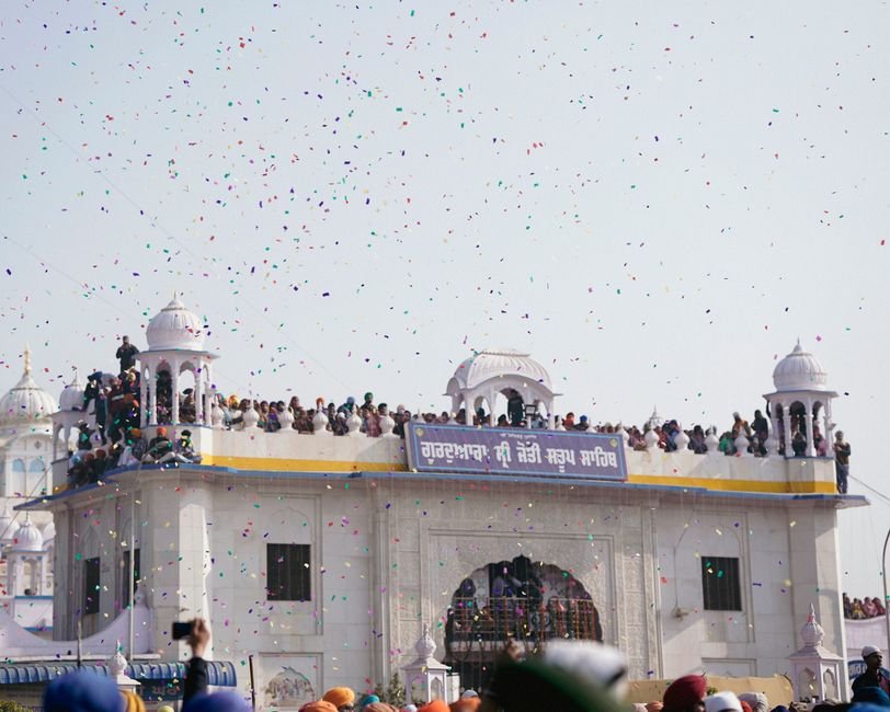 Ludhiana: Community Health Officers Protest Unfulfilled Demands, Stage Hunger Strike Crowds gather at a classic dome for a traditional festival with colorful confetti in the air.