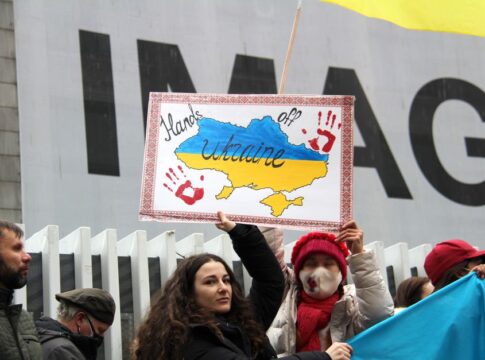 Demonstrators rally for Ukraine in Vancouver, holding signs and flags during a peaceful protest.