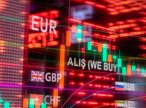 Dynamic forex trading concept with currency symbols and candlestick chart illuminated on screen.