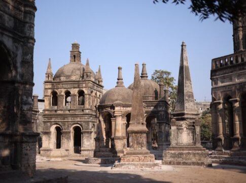 Explore ancient architectural structures in a sunlit historical cemetery, showcasing rich heritage.