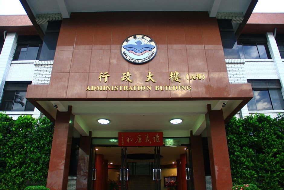 Mansa Administration Postpones Cement Plant Meeting Amidst Villager Protests Front view of Ming Chuan University's Administration Building entrance, showcasing its architectural design.