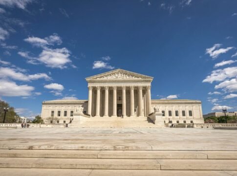 Front view of the United States Supreme Court building on a sunny day with blue sky and clouds. Front view of the United States Supreme Court building on a sunny day with blue sky and clouds.