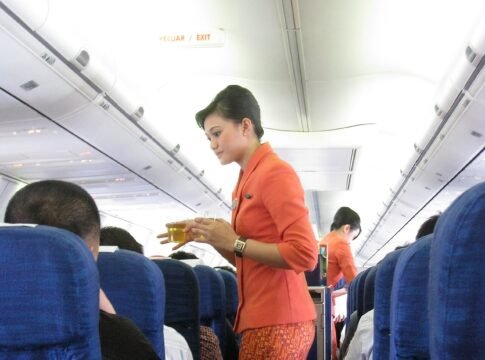 Garuda Indonesia flight attendants serving refreshment. The new in-flight costumes for Garuda Indonesia stewardesses are inspired by the traditional Kartini-styled kebaya for the upper torso with bat…