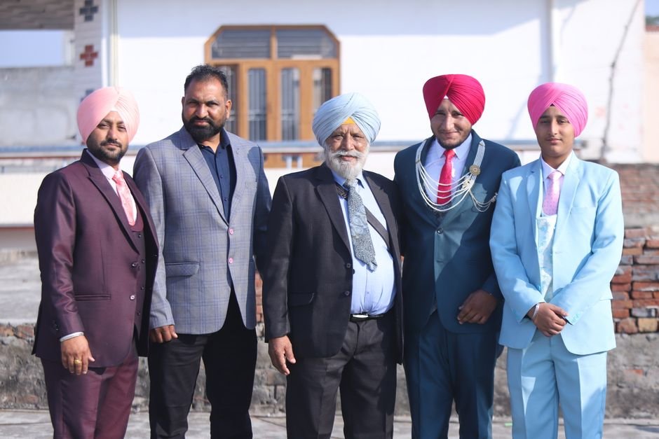 Kapurthala District Reviews Paddy Milling Progress, Secures Rake Availability Group of Punjabi men in traditional attire and suits, posing outdoors.