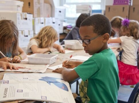 Group of children focused on educational activities in a classroom setting. Group of children focused on educational activities in a classroom setting.