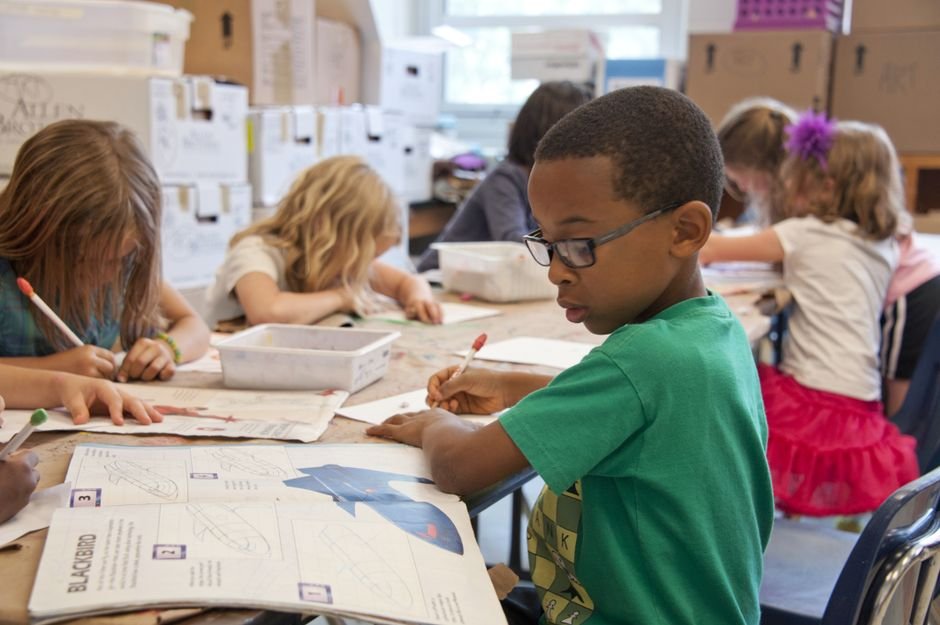 UNDRR and WMO Launch Child-Friendly Booklet on Early Warning Systems Group of children focused on educational activities in a classroom setting.