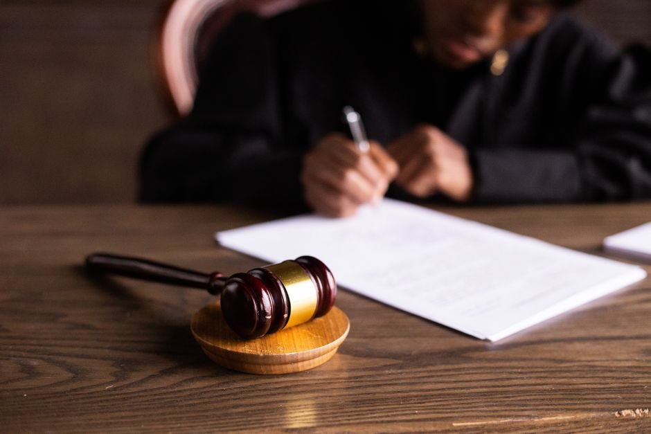 Andhra Pradesh: Visakhapatnam District Legal Services Authority Reviews National Lok Adalat Preparations Judge signing documents at desk with focus on gavel, representing law and justice.