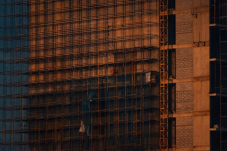 Noida Protest Aftermath: Workers Face Financial Ruin, Joblessness Four Months On Scaffolding and incomplete building structure at sunset in Noida, India.