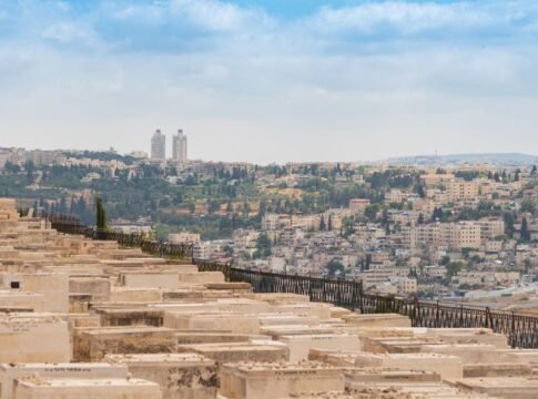 Scenic view of Jerusalem, Israel, featuring a historic cemetery and urban landscape under a blue sky.